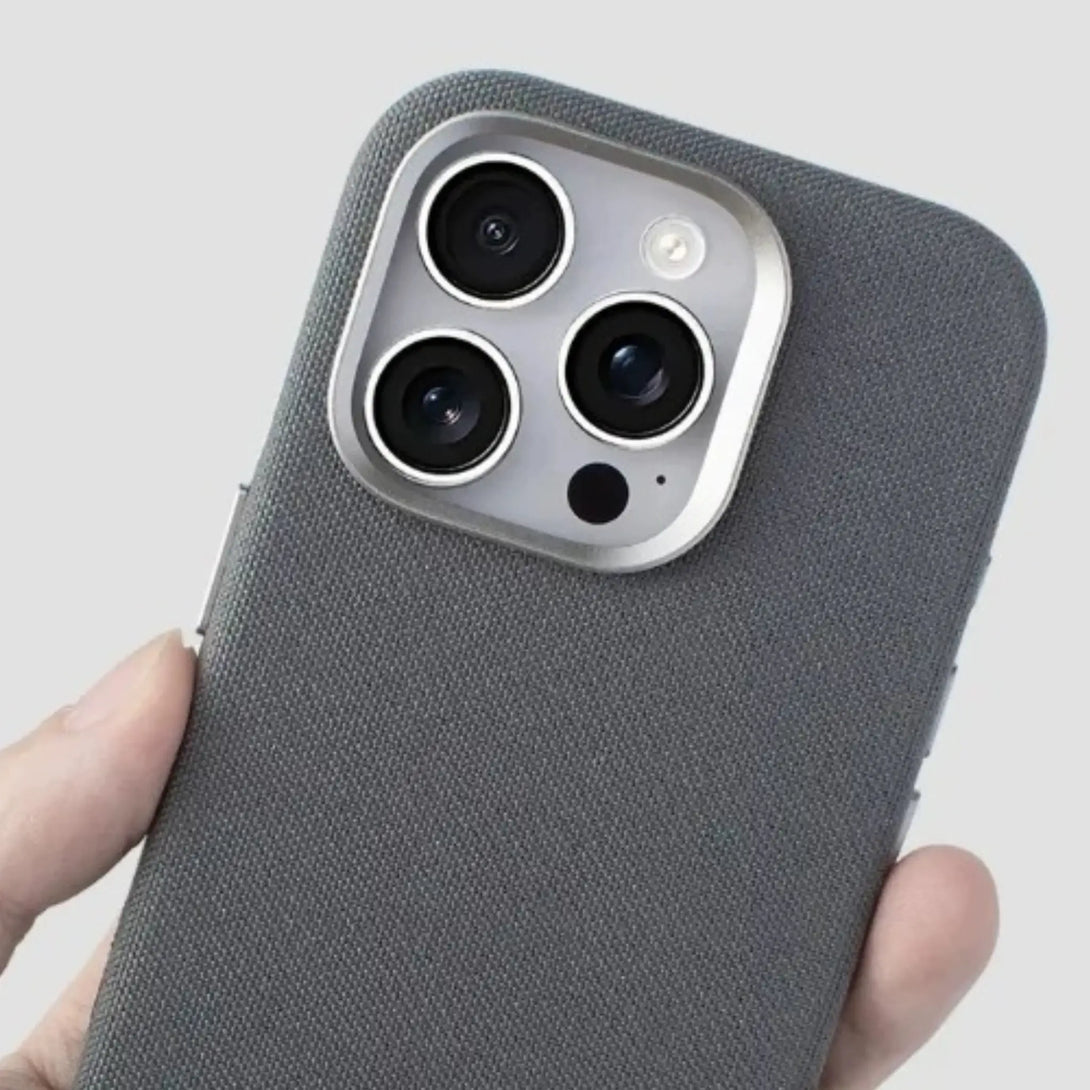 Dark gray textured iPhone case held by a hand showing camera bumper