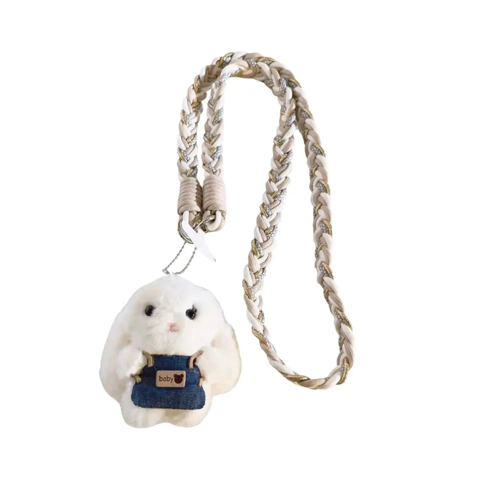 White fluffy bunny plush phone charm with denim overalls attached to a braided beige crossbody strap.
