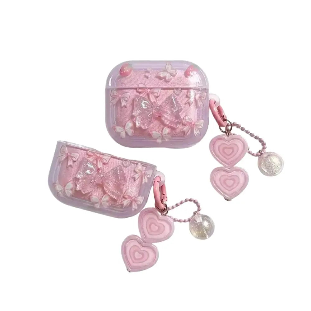 Pink butterfly AirPods case in clear acrylic with 3D bows and heart charm keychains, front view