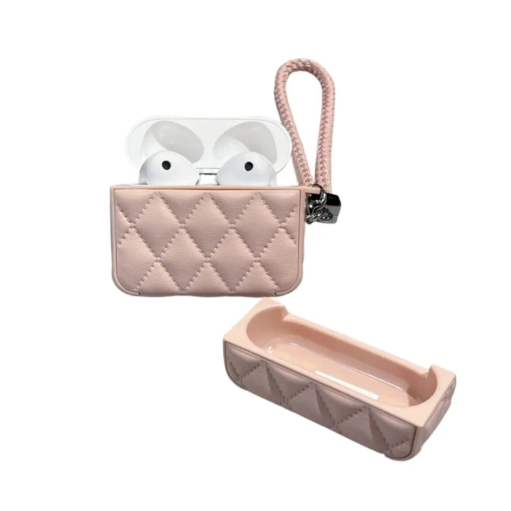 Quilted faux leather AirPods case in pink, lid open with earbuds inside